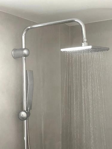 a shower with a shower head in a bathroom at DL Santorini in Monolithos
