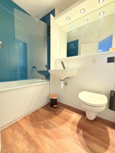 a bathroom with a toilet and a sink and a tub at Kyriad Blois Sud - Vineuil in Vineuil