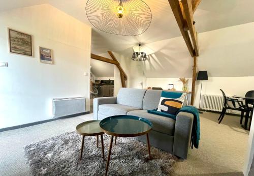 a living room with a couch and a table at L'Appart'Anjou in Cantenay-Épinard