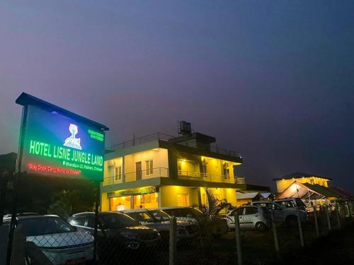 a building with a sign in front of a parking lot at Hotel Lisne jungle land in Bharatpur