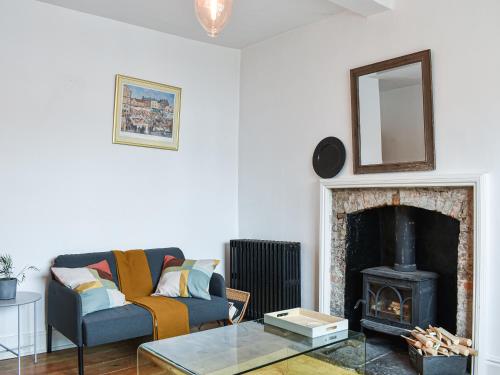 a living room with a couch and a fireplace at Market Place View in Knaresborough