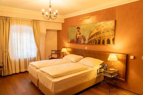 a bedroom with a large bed and a painting on the wall at Hotel Ptuj in Ptuj