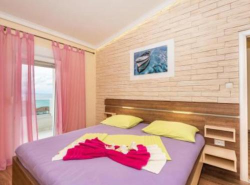 a bedroom with a bed with two towels on it at Villa Goldfield in Gradac