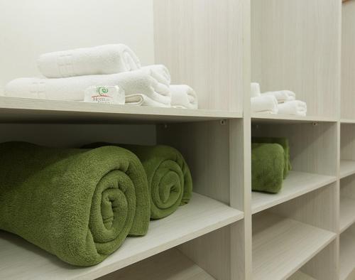 a bathroom with green towels and white towels at Hotel do Feijão in Cachoeira Paulista