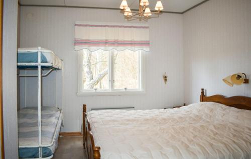 a bedroom with a white bed and a window at Sommarstuga med strandtomt in Ronneby