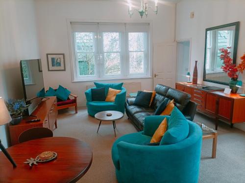 a living room with blue couches and a table at Spacious 2 bedroom apartment in Taunton