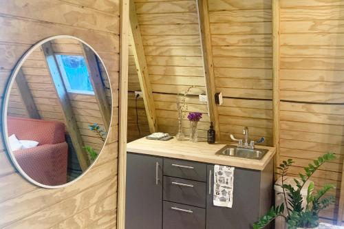 a bathroom with a sink and a mirror at Romantic Cozy Serene A Frame Mountain Cabin in Cayey