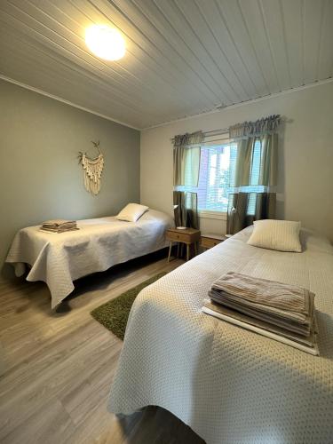 a bedroom with two beds and a window at Riihen Pirtti in Äkäslompolo