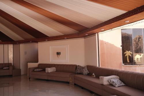 ein Wohnzimmer mit Sofa und großem Fenster in der Unterkunft Sunrise Echo Camp in Wadi Rum