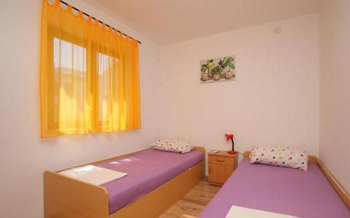 a bedroom with two beds and a window at Apartmani Suzi in Slatine