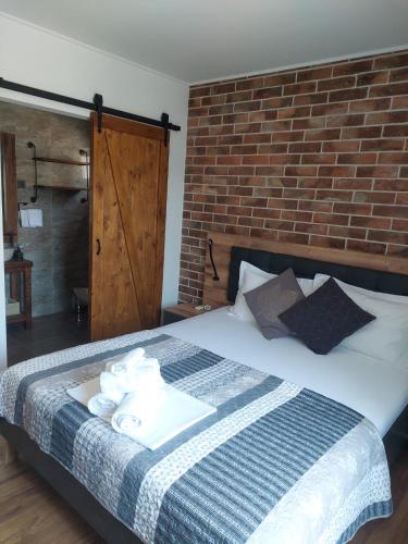 a bedroom with a bed with towels and a brick wall at Villa Nicoletta in Polača