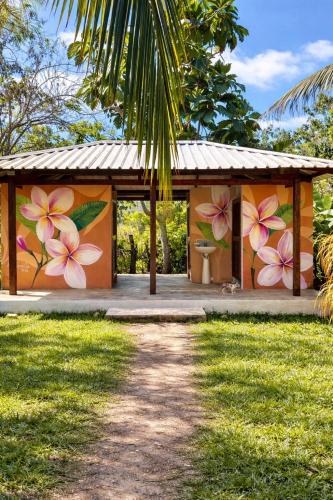 a building with a mural of flowers on it at Pomelo Hostal in Mingueo
