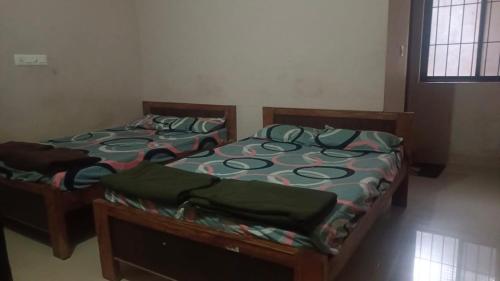 two twin beds in a room with at Amrutha Easy Stay in Kalasa