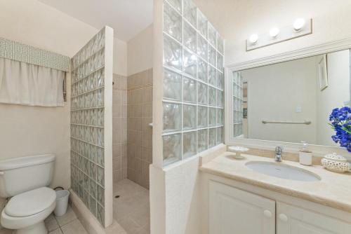 Un baño con inodoro, lavabo y espejo. en 82 Cherry Avenue, en Saint James