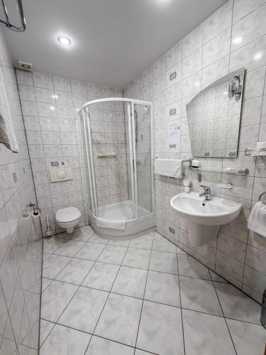 a bathroom with a shower and a sink and a toilet at Hotel Metro in Kłodzko