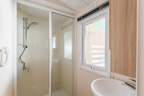 a bathroom with a glass shower and a sink at Camping Papillon Kinrooi 113 in Kinrooi