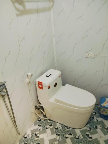 a white toilet in a bathroom with marble walls at Mũi Si Homestay Cửa Tùng in Vĩnh Bang