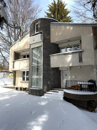 a brick house with a glass door in the snow at Villa Alexa in Borovets