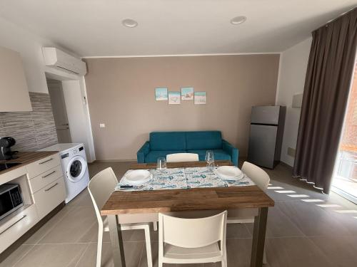 a living room with a table and a blue couch at Acquaviva Suites, Pool - View in San Vincenzo