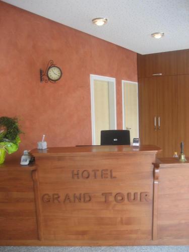a hotel grand tour desk with a clock on a wall at Hotel Grand Tour in Wesseling