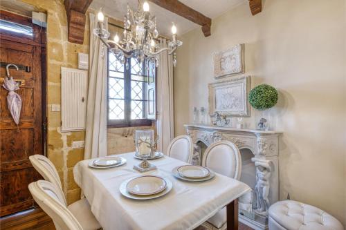 a dining room with a table and chairs and a chandelier at Charming City Stay close to Seafront in Birgu