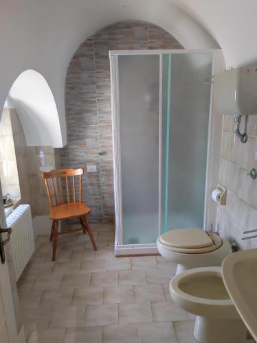 a bathroom with a shower and a toilet and a chair at Dimora San Pietro in Ferrandina