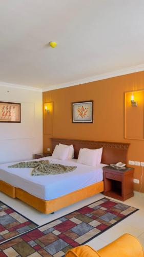 a bedroom with a large bed with orange walls at Grand Pyramids Hotel in Cairo