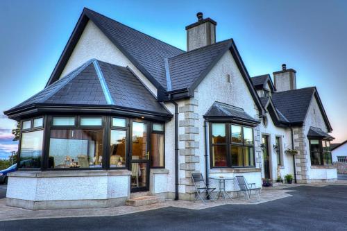 a house with a black roof and chairs at Walkers Nest in Carlingford