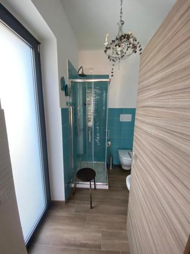 a bathroom with a glass shower and a chair at La Rosa di Tempalta in Roccadaspide