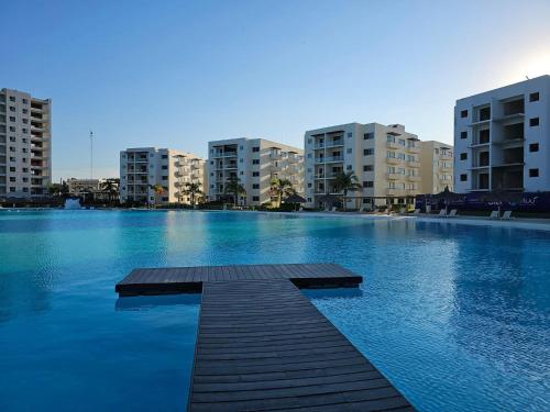 a large swimming pool with buildings in the background at Bluu Habitat Lagoons 206 in Mazatlán