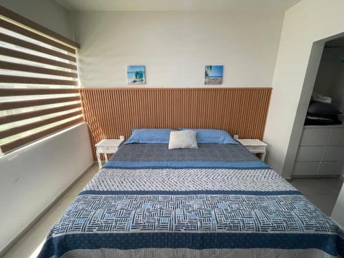 a bedroom with a bed with a blue comforter at Bluu Habitat Lagoons 206 in Mazatlán