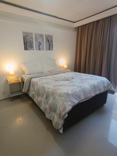 a bedroom with a large bed with two lamps at Bacacheri 5 Estrelas in Curitiba