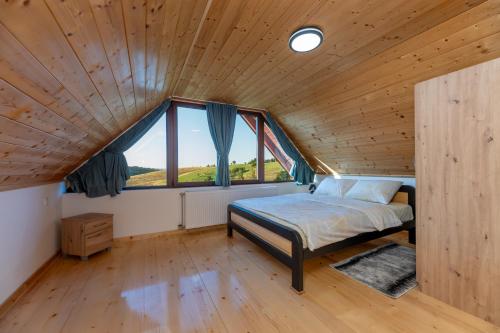 a bedroom with a bed and a large window at Vikendice Kutlešić in Čajetina