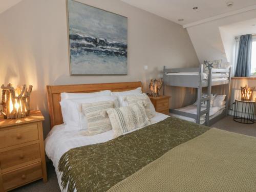 a bedroom with a large bed and a bath tub at The Boat House - Port Eynon in Swansea