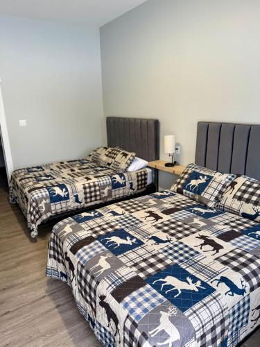 a room with two beds and a table with a bedskirts at The Moosehead in Glenwood