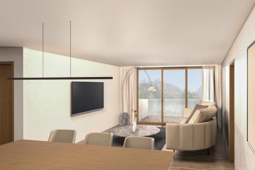 a dining room with a table and chairs and a television at Plavna Apartment in Scuol