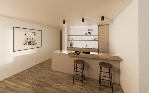 a kitchen with two stools and a counter in a room at Plavna Apartment in Scuol