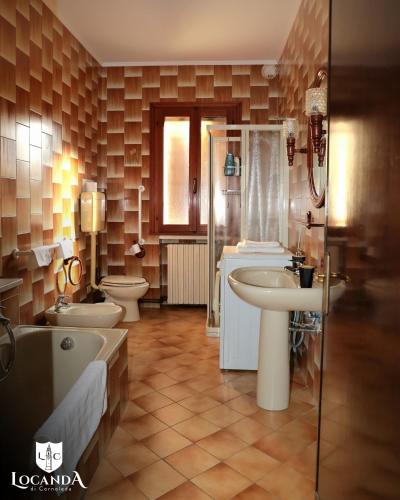 a bathroom with two toilets and a tub and sinks at Locanda di Cornoleda in Cinto Euganeo