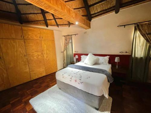 a bedroom with a large bed and wooden cabinets at Green Oasis Lodges in Harare