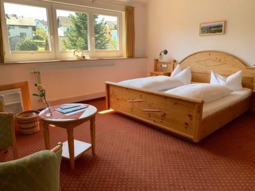 a bedroom with a large wooden bed and a table at Bürgerstüble in Sankt Peter