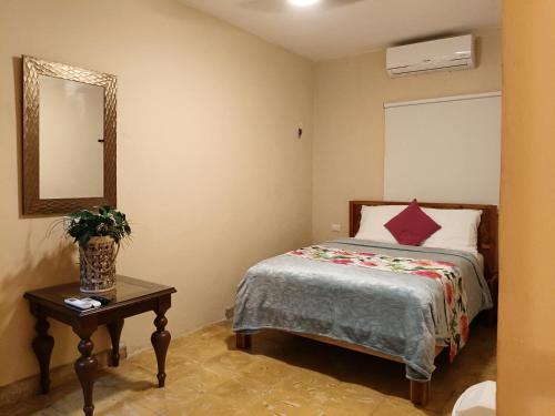 a bedroom with a bed and a table with a mirror at casa bajlum in Valladolid