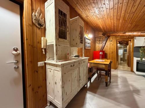 a kitchen with white cabinets and a wooden ceiling at Graziosa mansarda rustica - CIR VDA 0038 in Aosta