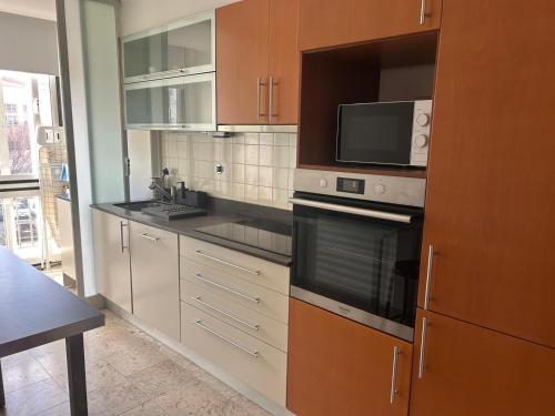 a kitchen with stainless steel appliances and a microwave at suites Lisboa areeiro in Lisbon