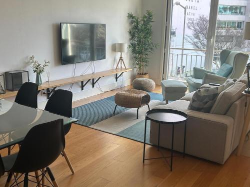 a living room with a couch and a tv on a wall at suites Lisboa areeiro in Lisbon