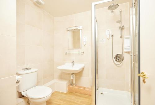 a bathroom with a toilet and a sink and a shower at George Hotel by Greene King Inns in Huntingdon