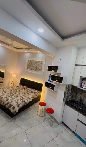 a bedroom with a bed and two red chairs in it at The dream studio in Noida