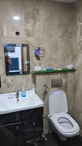 a bathroom with a sink and a toilet and a mirror at The dream studio in Noida