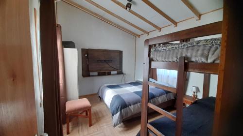 a bedroom with a bunk bed and a chair at Casa Torres in Curacautín