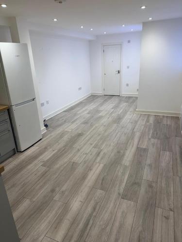 an empty room with wooden floors and white walls at Epsom High Street Apartment 6 in Epsom