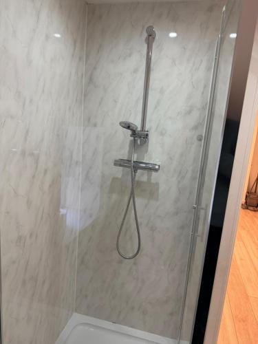 a shower with a hose in a bathroom at Epsom High Street Apartment 6 in Epsom